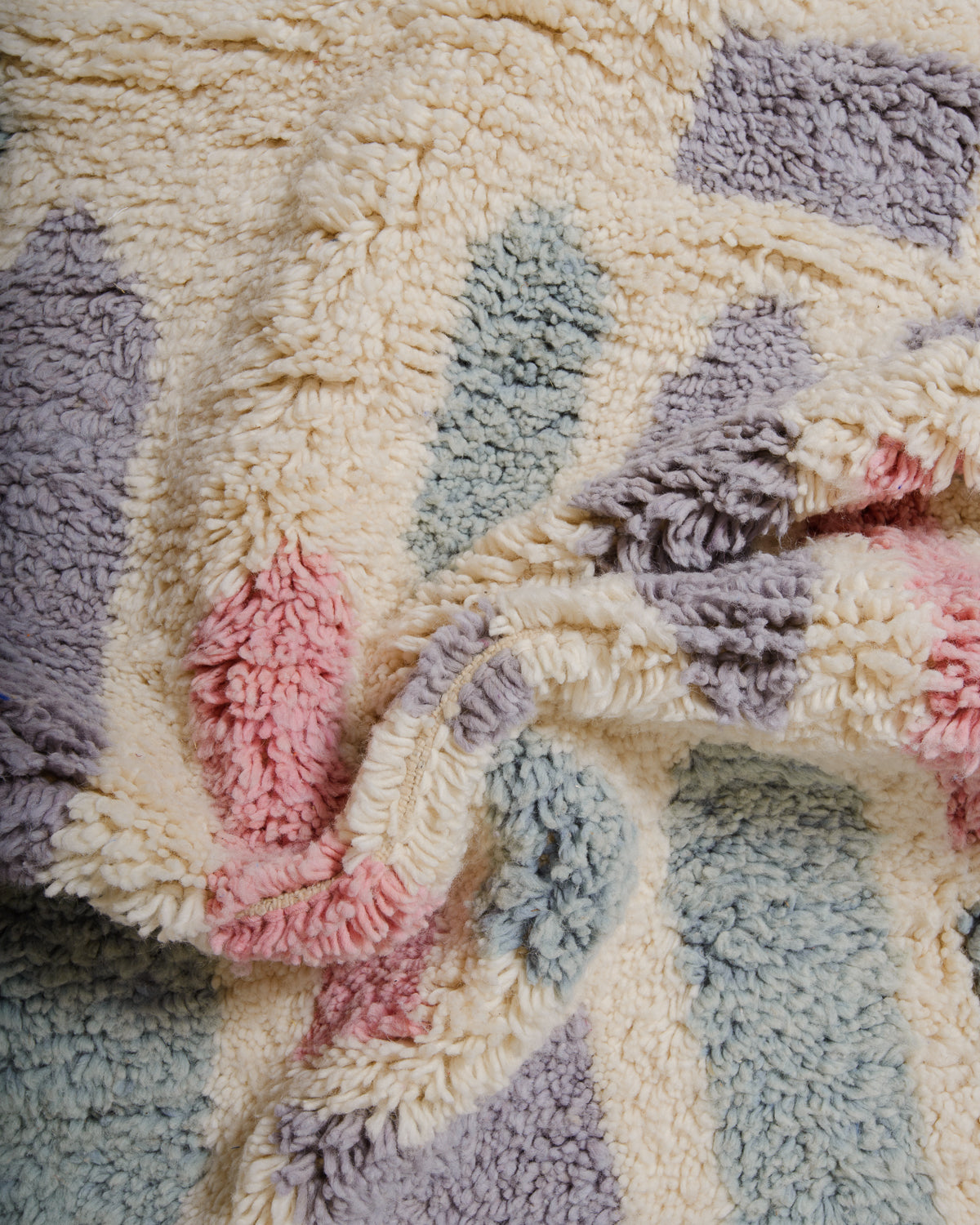 Detail of wool berber rug showing depth of pile and different coloured wool used.